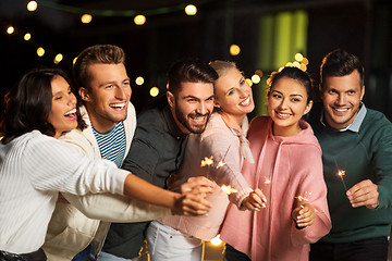 Image showing happy friends with sparklers at rooftop party