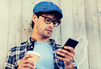 Image showing man with earphones and smartphone drinking coffee