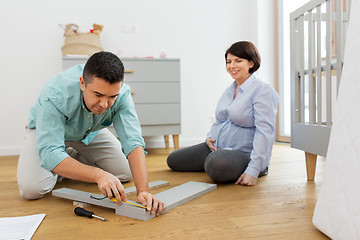 Image showing family couple assembling baby bed at home