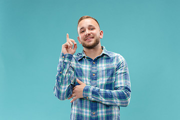 Image showing The happy business man standing and smiling against blue background.