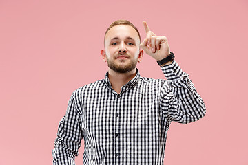 Image showing The happy business man standing and smiling against pink background.