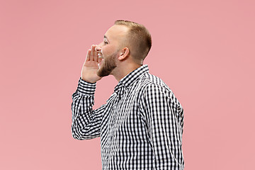 Image showing Isolated on pink young casual man shouting at studio