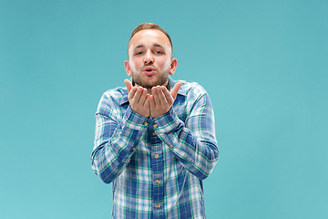 Image showing Portrait of attractive man with kiss isolated over blue background