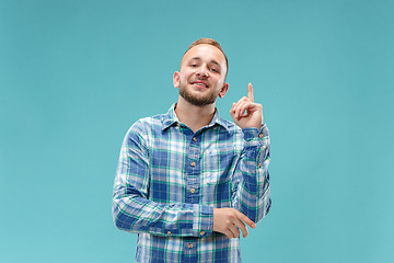 Image showing The happy business man standing and smiling against blue background.