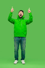 Image showing handsome bearded young man looking at camera isolated on green