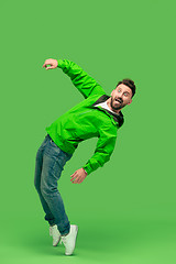 Image showing handsome bearded young man looking at camera isolated on green