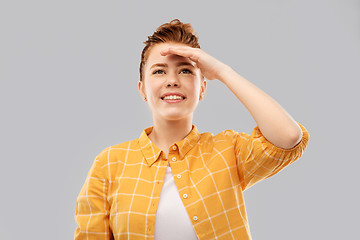 Image showing smiling red haired teenage girl looking far away