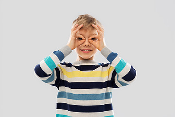 Image showing boy in pullover looking through finger glasses