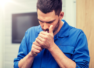 Image showing auto mechanic smoking cigarette at car workshop