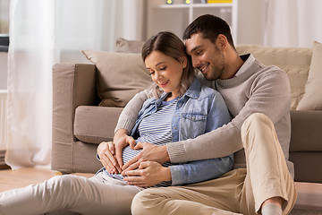 Image showing man with pregnant woman making hand heart at home