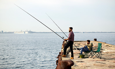 Image showing happy friends with fishing rods on pier