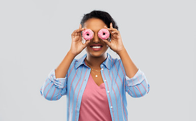 Image showing happy african american woman with eyes of donuts