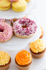 Image showing close up of glazed donuts and cupcakes on stand