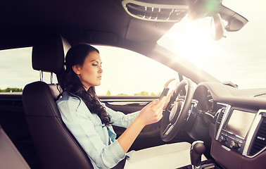 Image showing woman driving car with smarhphone