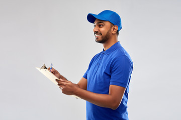 Image showing happy indian delivery man with clipboard in blue