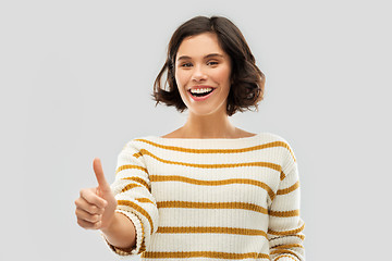 Image showing smiling woman in pullover showing thumbs up