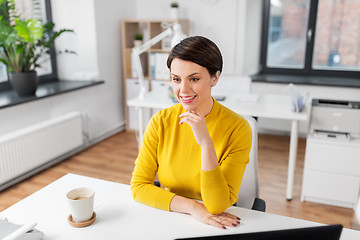 Image showing happy businesswoman sitting at office table