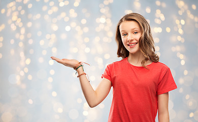 Image showing smiling teenage girl holding empty hand