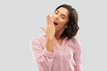 Image showing happy young sleepy woman in pajama yawning