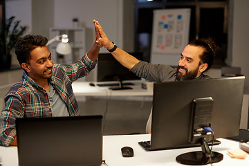 Image showing creative team making high five at night office