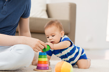 Image showing baby boy with father and pyramid toy at home