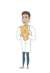 Image showing Young hispanic pediatrician holding teddy bear.