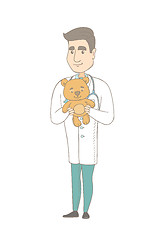 Image showing Young caucasian pediatrician holding teddy bear.