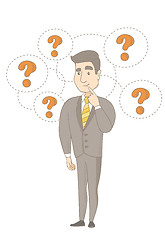 Image showing Young caucasian businessman under question marks.