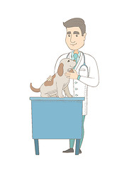 Image showing Young caucasian veterinarian examining dog.