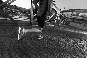 Image showing man jogging across the bridge in the city