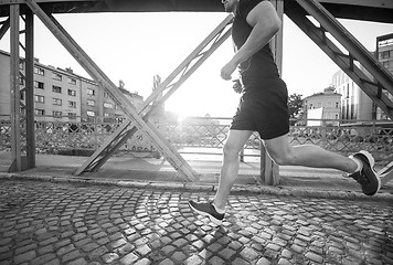 Image showing man jogging across the bridge at sunny morning