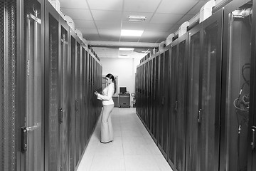 Image showing Female engineer working on a tablet computer in server room