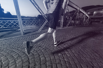 Image showing man jogging across the bridge in the city