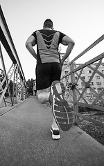 Image showing man jogging across the bridge at sunny morning