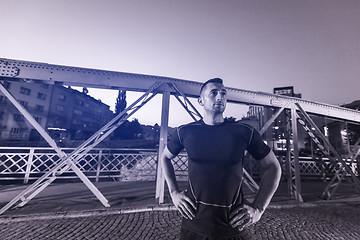 Image showing man jogging across the bridge in the city