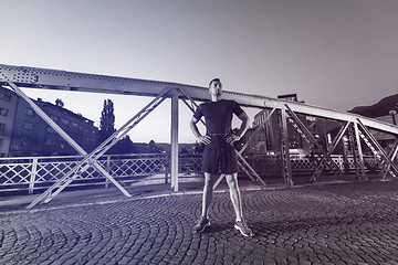 Image showing man jogging across the bridge in the city