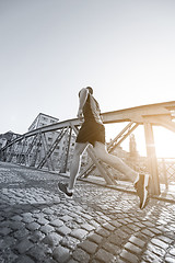 Image showing man jogging across the bridge at sunny morning