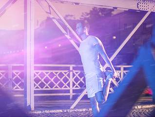 Image showing man jogging across the bridge in the city