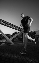 Image showing man jogging across the bridge in the city