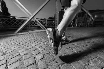 Image showing man jogging across the bridge in the city