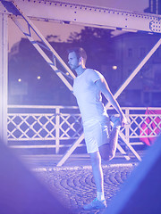 Image showing man jogging across the bridge in the city