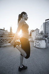 Image showing woman jogging across the bridge at sunny morning