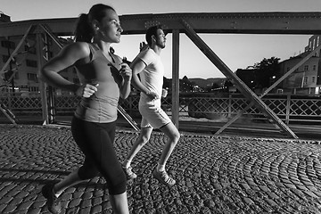 Image showing couple jogging across the bridge in the city