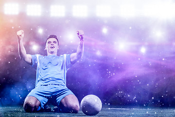 Image showing soccer player in front of big modern stadium with flares and lig