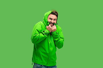 Image showing handsome bearded young man looking at camera isolated on green