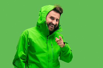 Image showing handsome bearded young man looking at camera isolated on green