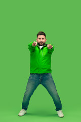 Image showing handsome bearded young man looking at camera isolated on green