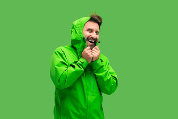 Image showing handsome bearded young man looking at camera isolated on green