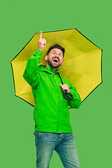 Image showing handsome bearded young man holding umbrella and looking at camera isolated on white