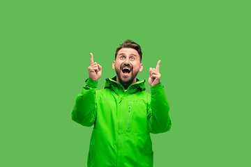 Image showing handsome bearded young man looking at camera isolated on green